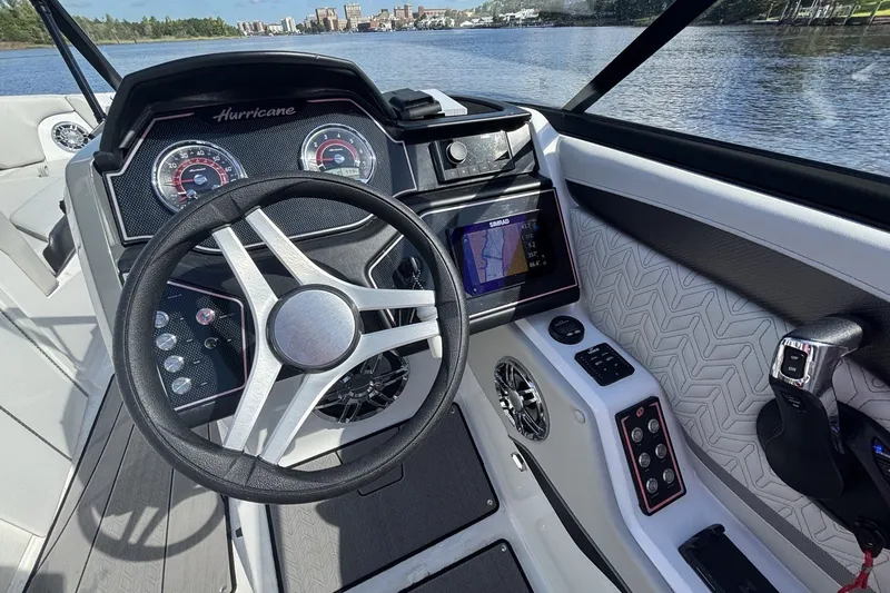 Slide: The Image of 2024 Hurricane SunDeck 2600 OB boat dashboard with steering wheel and navigation display. - 10
