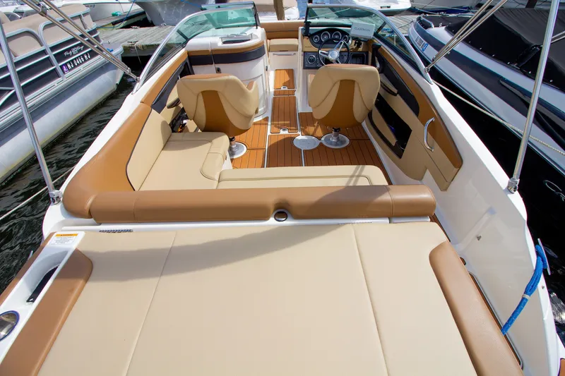 Slide: The Image of The image shows the cockpit of a 2015 Sea Ray 220 Sundeck with beige upholstery. - 31