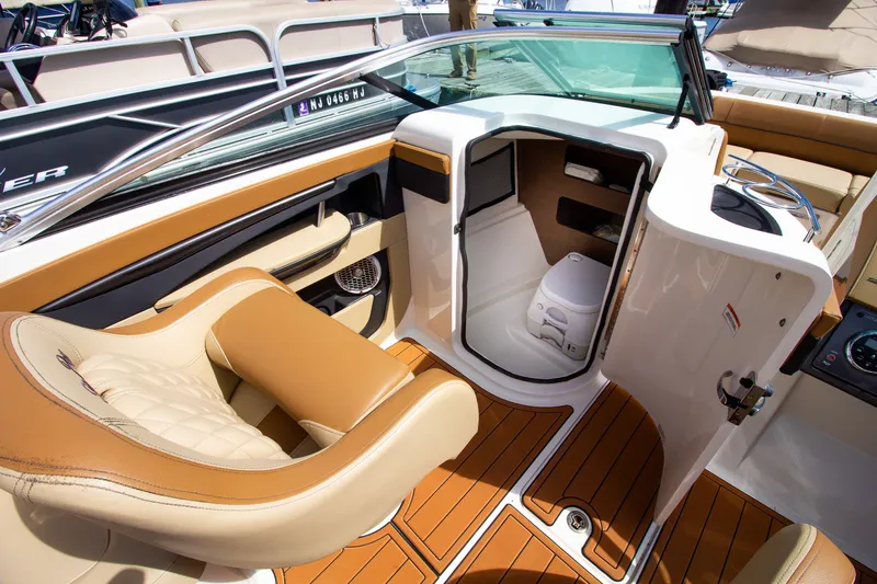 Slide: The Image of The image shows the cockpit of a 2015 Sea Ray 220 Sundeck with beige and brown interior. - 39