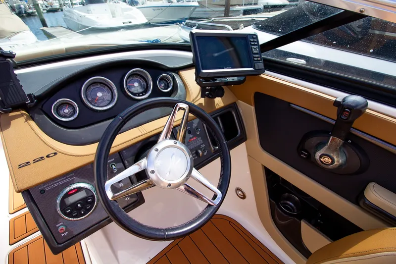 Slide: The Image of The cockpit of a 2015 Sea Ray 220 Sundeck with steering wheel and instruments. - 44