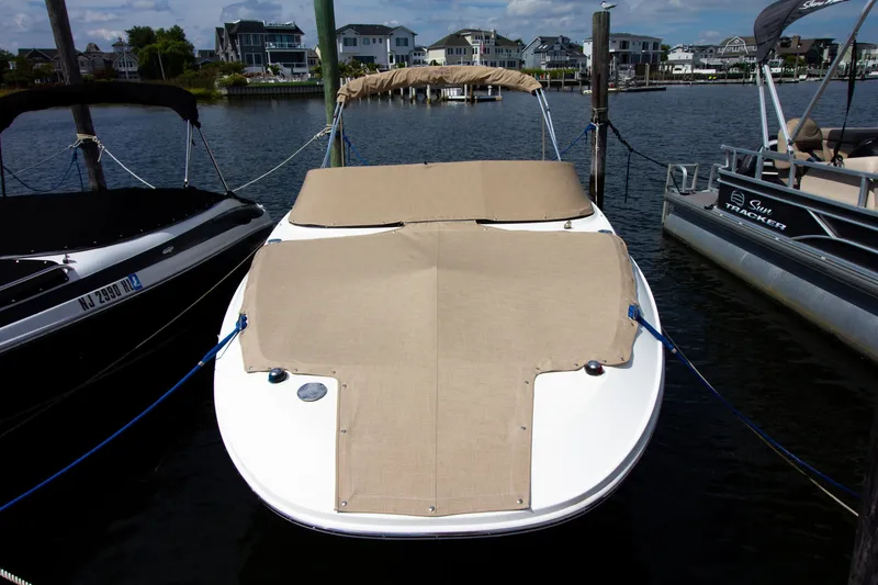 Slide: The Image of A 2015 Sea Ray 220 Sundeck docked, featuring a beige cover. - 19