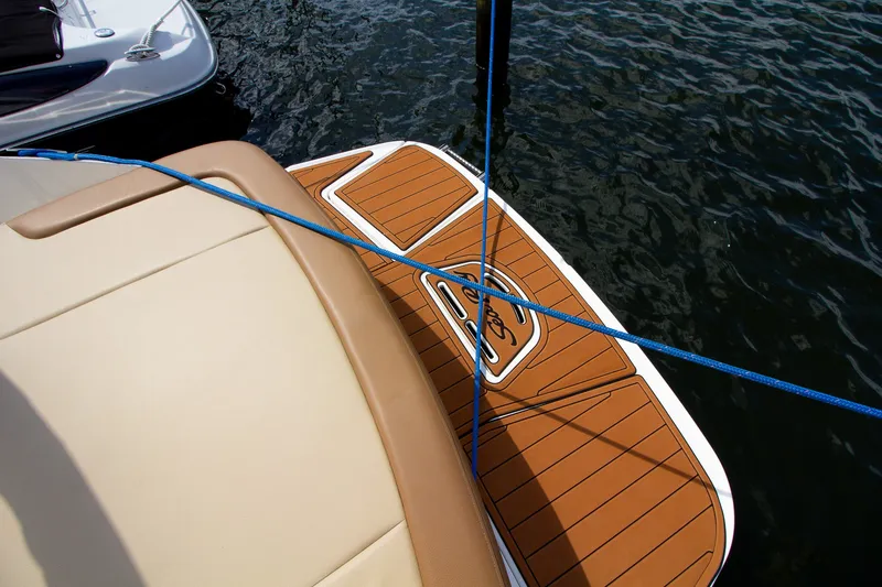 Slide: The Image of The image shows the stern of a 2015 Sea Ray 220 Sundeck with a sleek teak deck. - 26