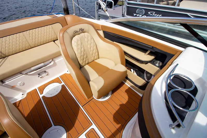 Slide: The Image of Interior of the 2015 Sea Ray 220 Sundeck with beige and brown seats, wood flooring, and cup holders. - 42