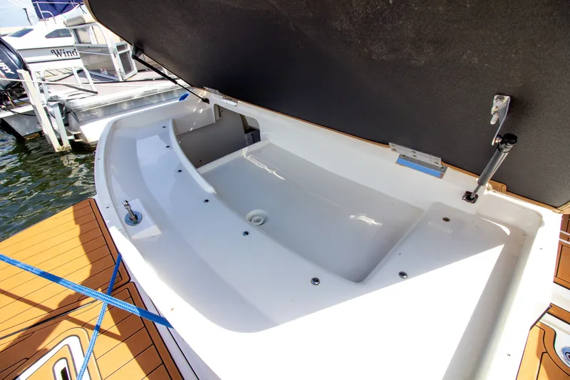 Slide: The Image of An open storage compartment on a Sea Ray 220 Sundeck boat docked at a marina. - 28