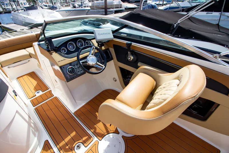 Slide: The Image of The image shows the cockpit of a Sea Ray 220 Sundeck boat with a sleek steering wheel and Garmin navigation. - 43
