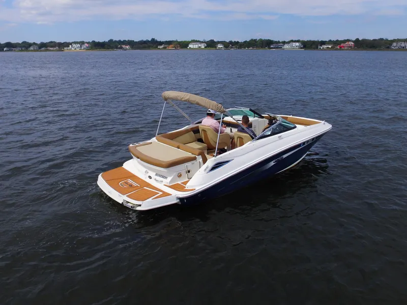 Slide: The Image of A 2015 Sea Ray 220 Sundeck on calm waters with two people on board. - 4