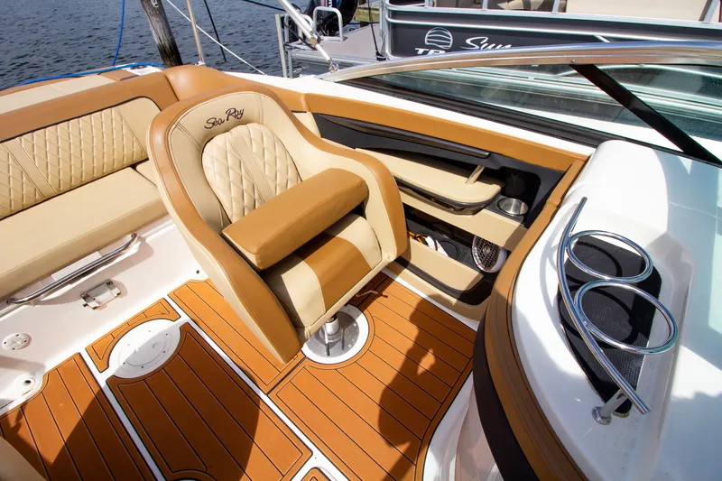 Slide: The Image of Interior of a 2015 Sea Ray 220 Sundeck with beige and brown upholstery and wood flooring. - 41