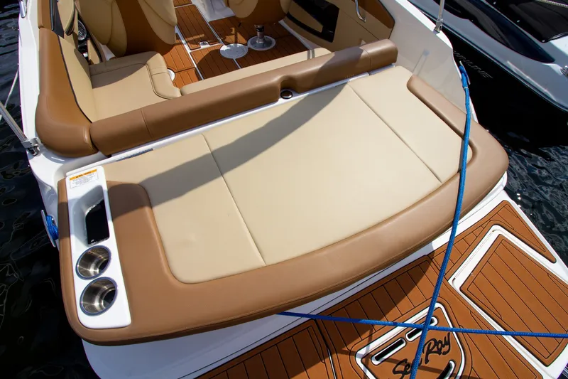 Slide: The Image of The image shows the stern of a 2015 Sea Ray 220 Sundeck with beige upholstery and teak flooring. - 27