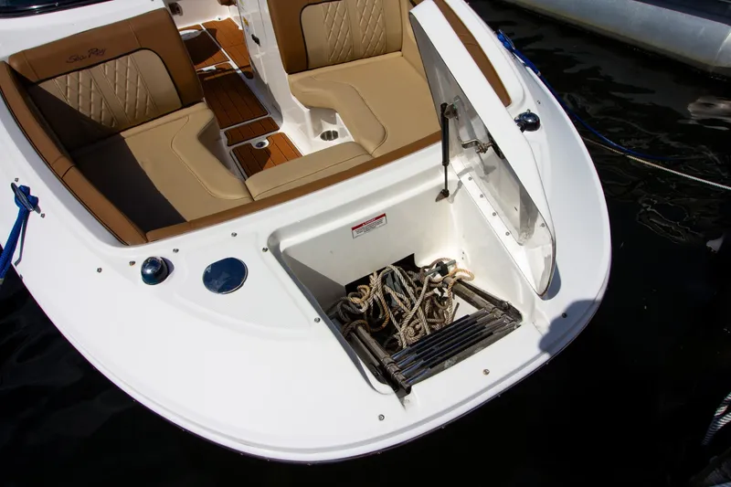 Slide: The Image of A 2015 Sea Ray 220 Sundeck with an open bow hatch showing ropes and a ladder. - 23