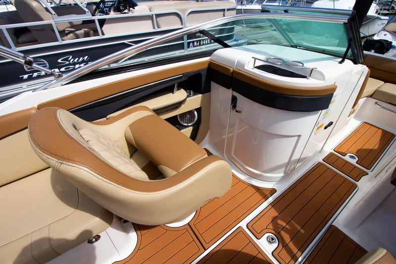 Slide: The Image of The image shows the cockpit of a 2015 Sea Ray 220 Sundeck with beige leather seats. - 38
