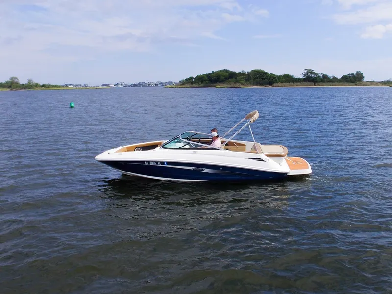 Slide: The Image of A 2015 Sea Ray 220 Sundeck on calm water with a driver on board. - 9