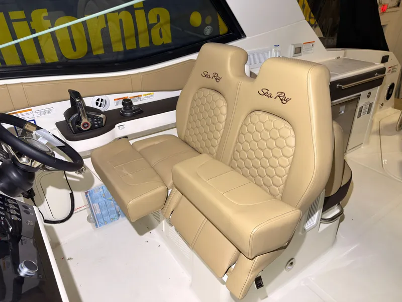 Slide: The Image of The image shows beige leather seats of a Sea Ray Sundancer 320 Outboard with embroidered logo. - 17