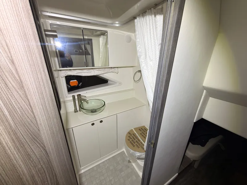Slide: The Image of The image shows a modern boat bathroom with a sink, mirror, and shower. - 37