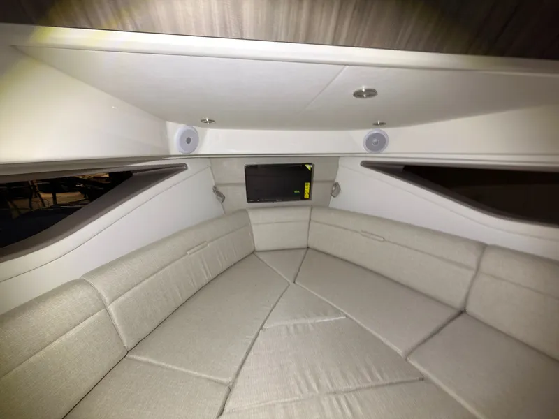 Slide: The Image of Interior of a Sea Ray Sundancer 320 Outboard with beige upholstered seating and a built-in TV. - 35