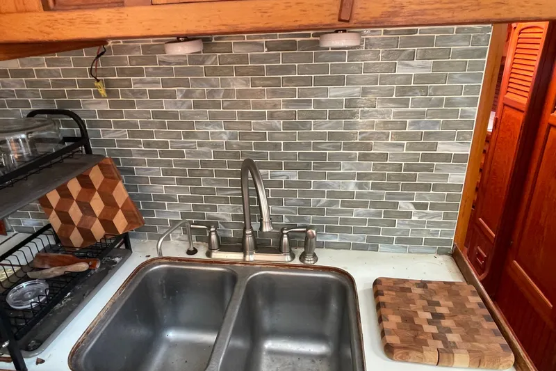 Slide: The Image of Galley kitchen in 1986 Slocum 43 sailboat with double sink and tiled backsplash. - 27