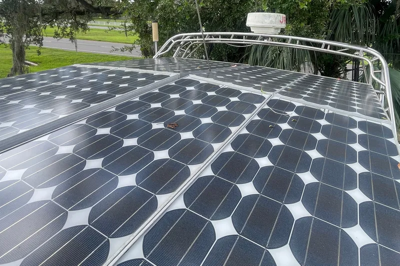 Slide: The Image of Solar panels on a 1986 Slocum 43 boat, surrounded by greenery. - 17