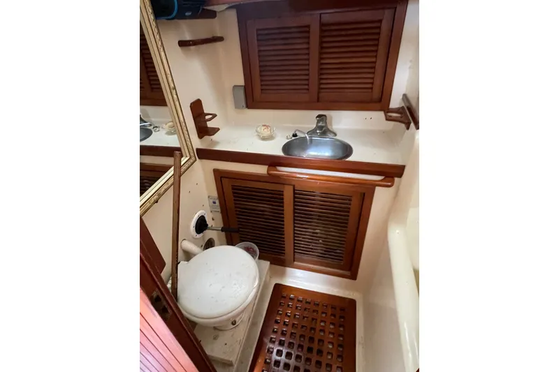 Slide: The Image of 1986 Slocum 43 yacht bathroom with wooden cabinets, sink, and toilet. - 41