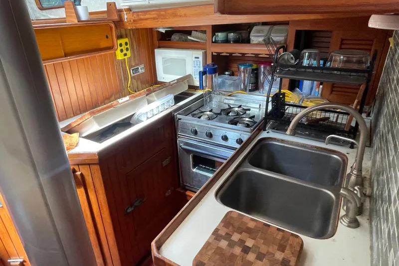 Slide: The Image of Compact kitchen in a 1986 Slocum 43 sailboat with stove, sink, and microwave. - 28