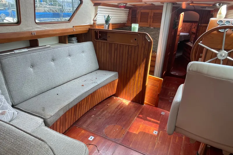Slide: The Image of Interior of a 1986 Slocum 43 sailboat with wooden paneling and seating area. - 24