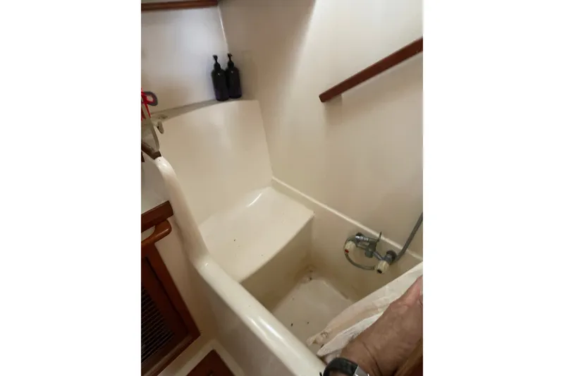 Slide: The Image of Interior of 1986 Slocum 43 sailboat bathroom with shower and wooden accents. - 48