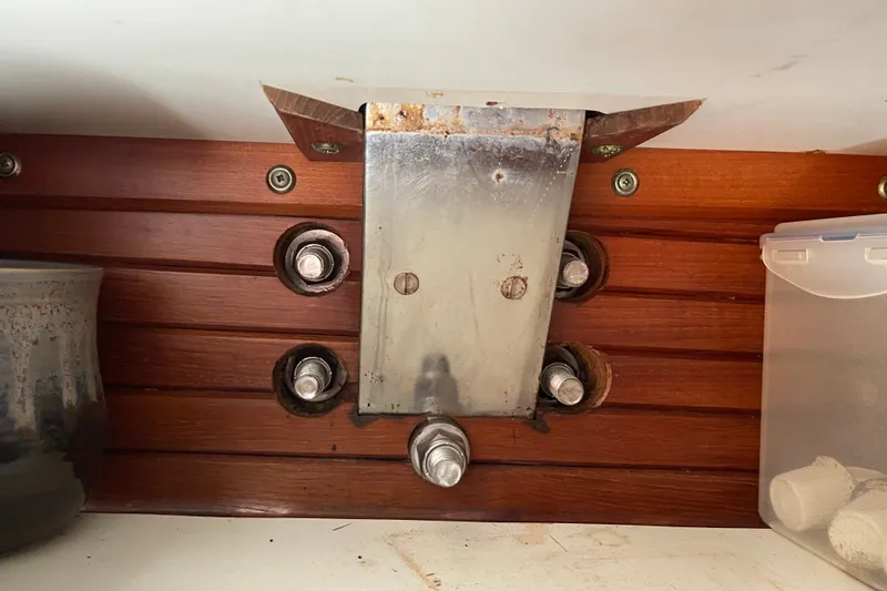 Slide: The Image of Metal bracket and bolts on wooden panel inside 1986 Slocum 43 boat. - 42