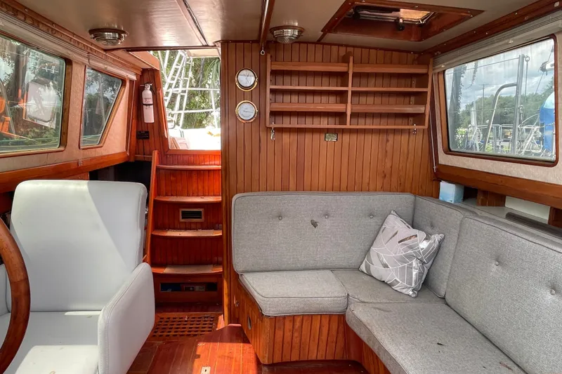 Slide: The Image of Interior of a 1986 Slocum 43 sailboat with wooden paneling and gray seating. - 20