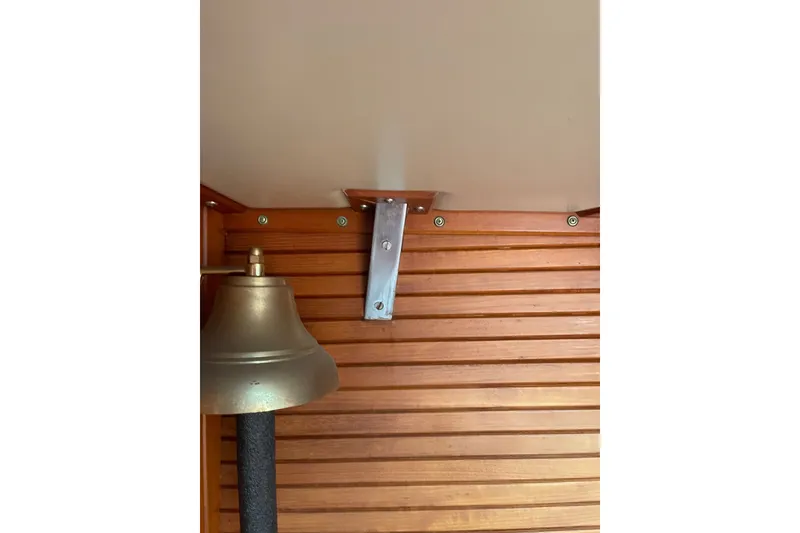 Slide: The Image of Brass bell on wooden panel, Slocum 43 yacht interior, 1986 model. - 44