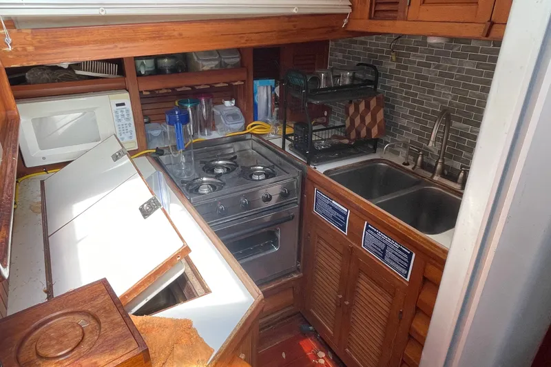 Slide: The Image of Compact galley kitchen in a 1986 Slocum 43 sailboat with stove, sink, and microwave. - 25