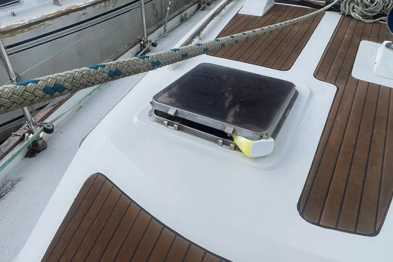 Slide: The Image of Deck of 1986 Slocum 43 sailboat with open hatch and wooden flooring. - 13