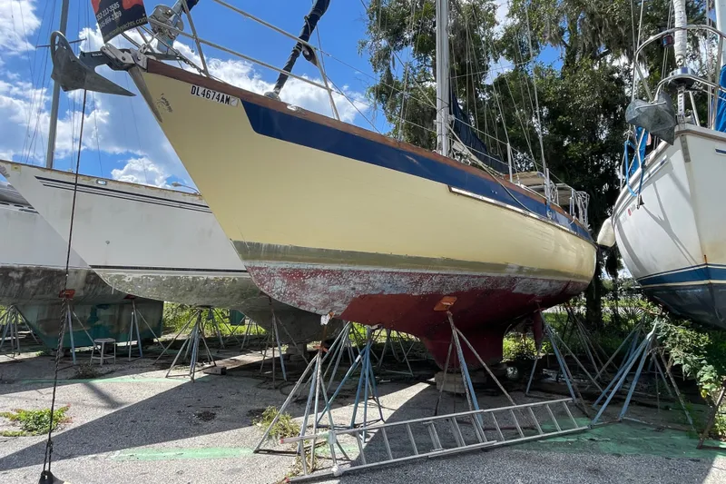The Image of 1986 Slocum 43 sailboat on stands, undergoing maintenance in a boatyard. - 0