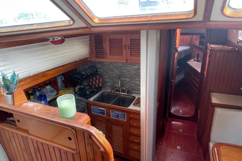 Slide: The Image of Interior of 1986 Slocum 43 sailboat with wooden cabinetry and compact kitchen area. - 31