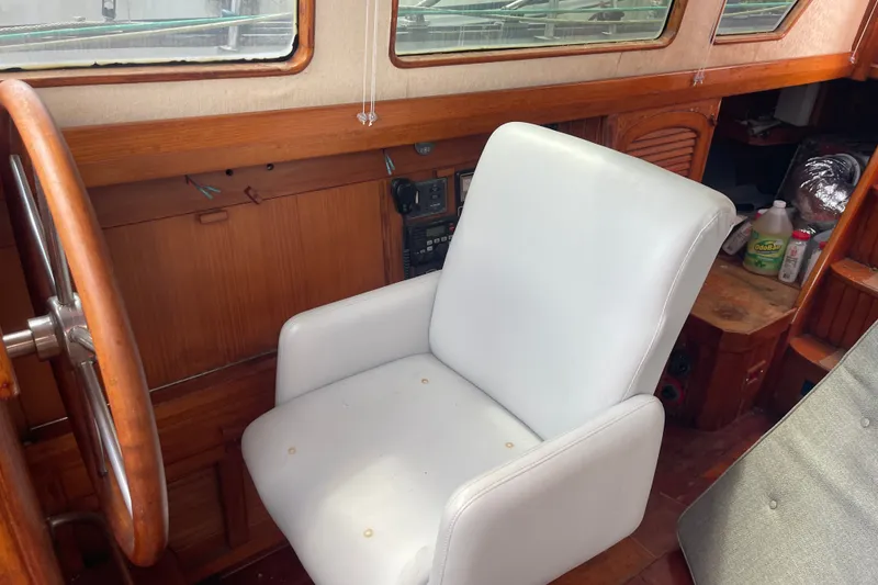 Slide: The Image of Interior of 1986 Slocum 43 sailboat with white captain's chair and wooden helm. - 32