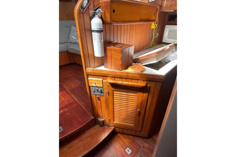 Slide: The Image of Interior of 1986 Slocum 43 sailboat with wooden cabinetry and fire extinguisher. - 23