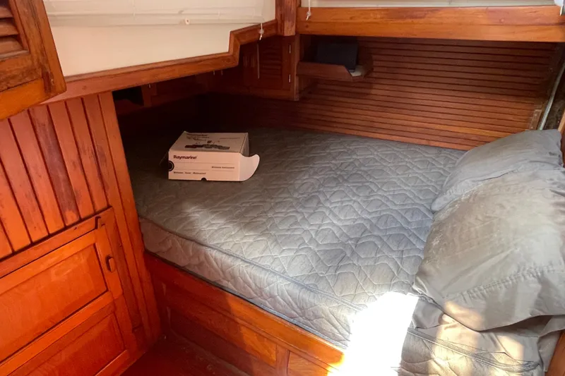 Slide: The Image of Cozy cabin interior of 1986 Slocum 43 sailboat with quilted bed and Raymarine box. - 36