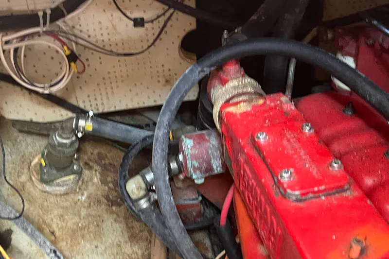 Slide: The Image of Engine compartment of a 1986 Slocum 43 sailboat, featuring red engine components and wiring. - 49