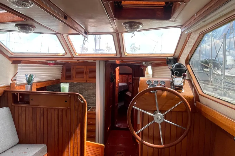 Slide: The Image of Interior of a 1986 Slocum 43 sailboat with wooden steering wheel and cozy cabin. - 21