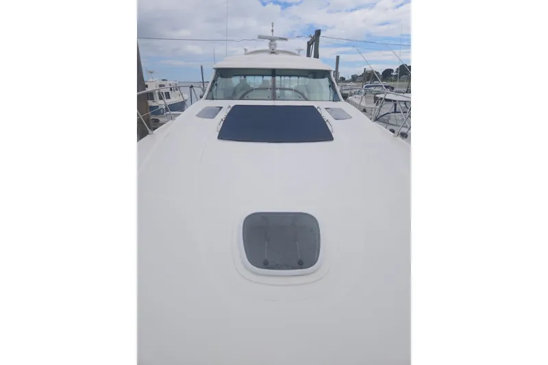 Slide: The Image of 2010 Sea Ray 580 Sundancer yacht deck with hatch and sunpad, docked at marina. - 18