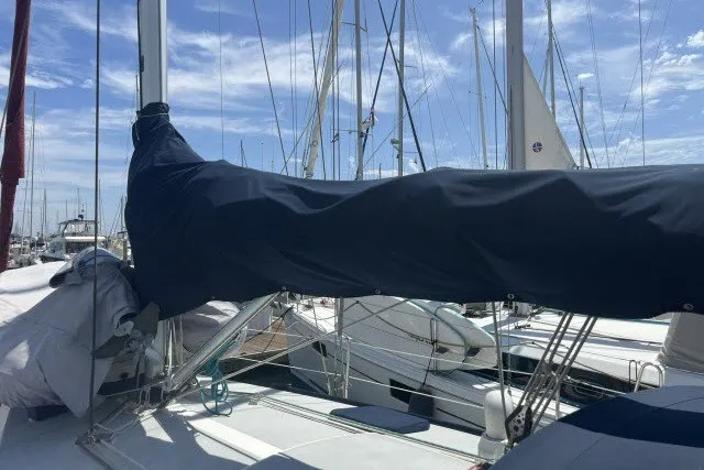 Slide: The Image of Sailboat deck view of a 1990 Catalina 42, with covered sails in a marina. - 34