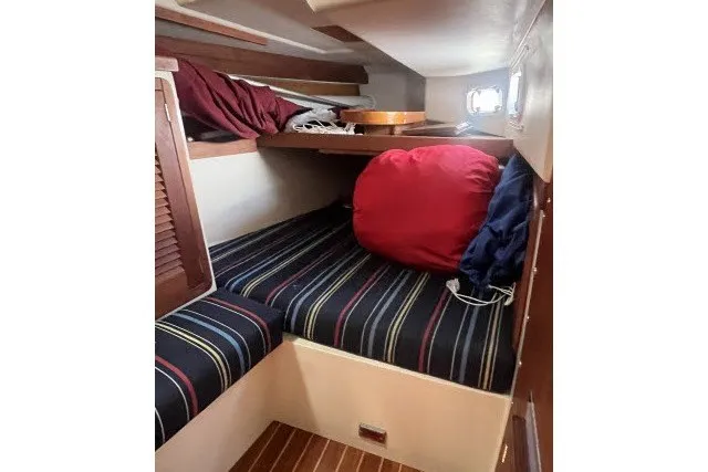 Slide: The Image of Cozy cabin interior of 1990 Catalina 42 sailboat with striped bedding and wooden accents. - 16