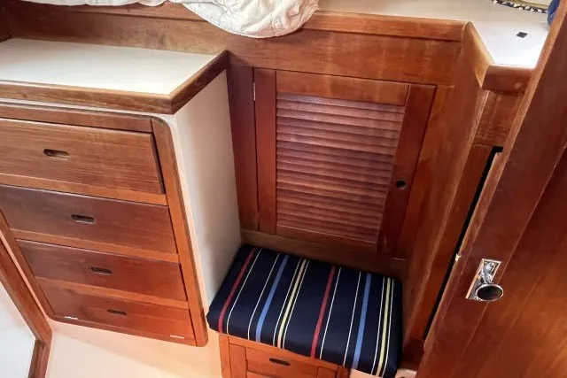Slide: The Image of Interior of 1990 Catalina 42 sailboat with wooden cabinetry and striped cushion seat. - 15