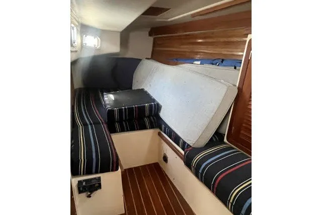 Slide: The Image of Interior cabin of a 1990 Catalina 42 sailboat with striped cushions and wooden flooring. - 18