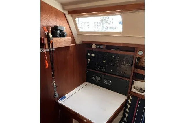 Slide: The Image of Navigation station inside 1990 Catalina 42 sailboat, featuring control panels and wooden interior. - 6