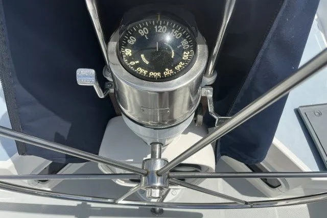 Slide: The Image of Compass on a 1990 Catalina 42 sailboat, featuring a stainless steel steering wheel. - 23