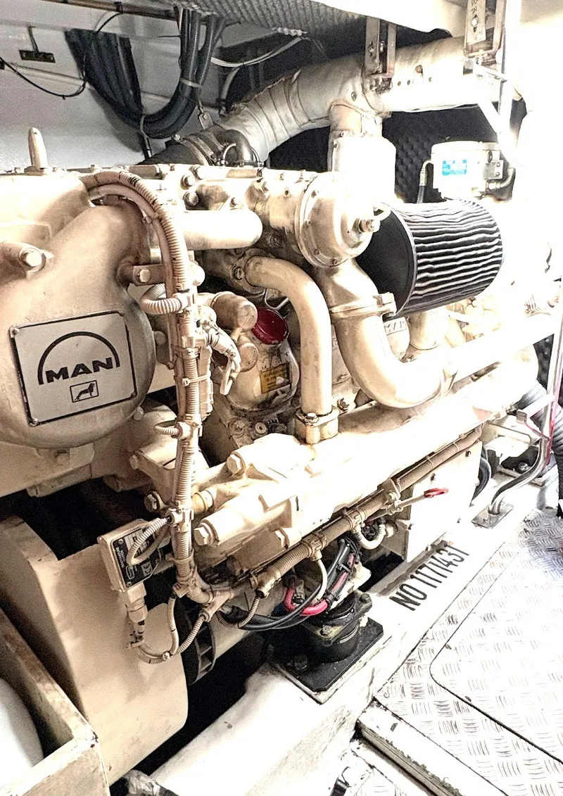 Slide: The Image of The engine room of a 2000 Sunseeker Predator 56 features a MAN engine with complex piping. - 37
