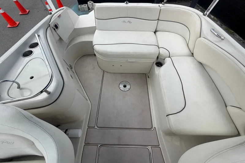 Slide: The Image of 2008 Sea Ray 240 Sundeck interior with white seating and built-in sink. - 73