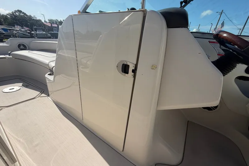 Slide: The Image of 2008 Sea Ray 240 Sundeck interior, featuring seating and helm area under clear blue sky. - 48
