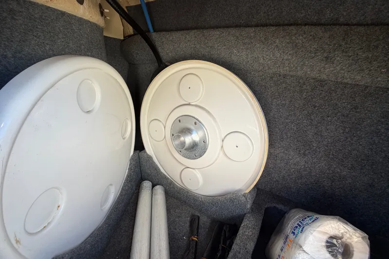Slide: The Image of Storage compartment in a 2008 Sea Ray 240 Sundeck with boat accessories and supplies. - 27