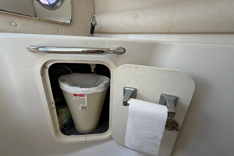Slide: The Image of Interior of 2008 Sea Ray 240 Sundeck showing storage compartment with trash bin and toilet paper. - 38