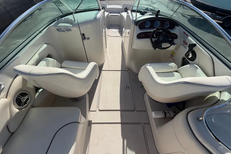 Slide: The Image of 2008 Sea Ray 240 Sundeck interior with white seating and dashboard view. - 29
