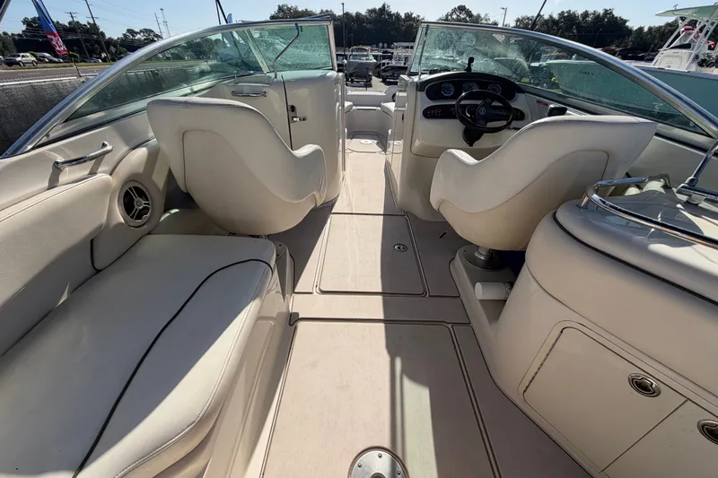 Slide: The Image of 2008 Sea Ray 240 Sundeck interior with white seating and steering console. - 28